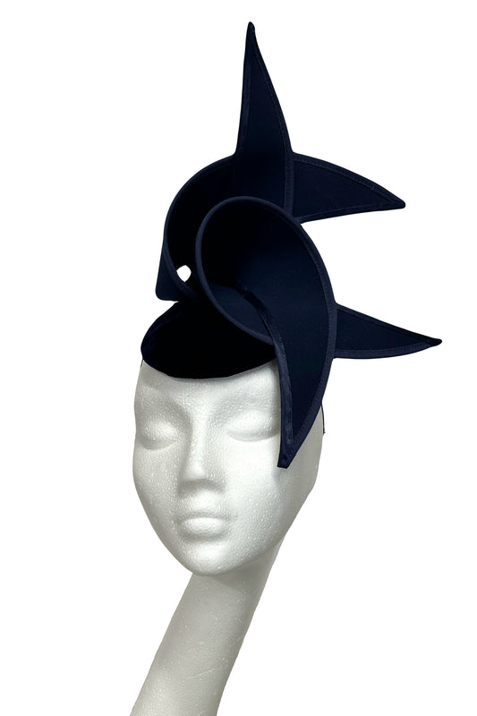 Navy blue fascinator on a mannequin head against a white background