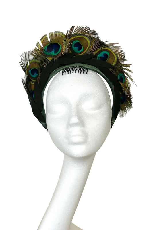 Peacock feather headband on a mannequin head against a white background