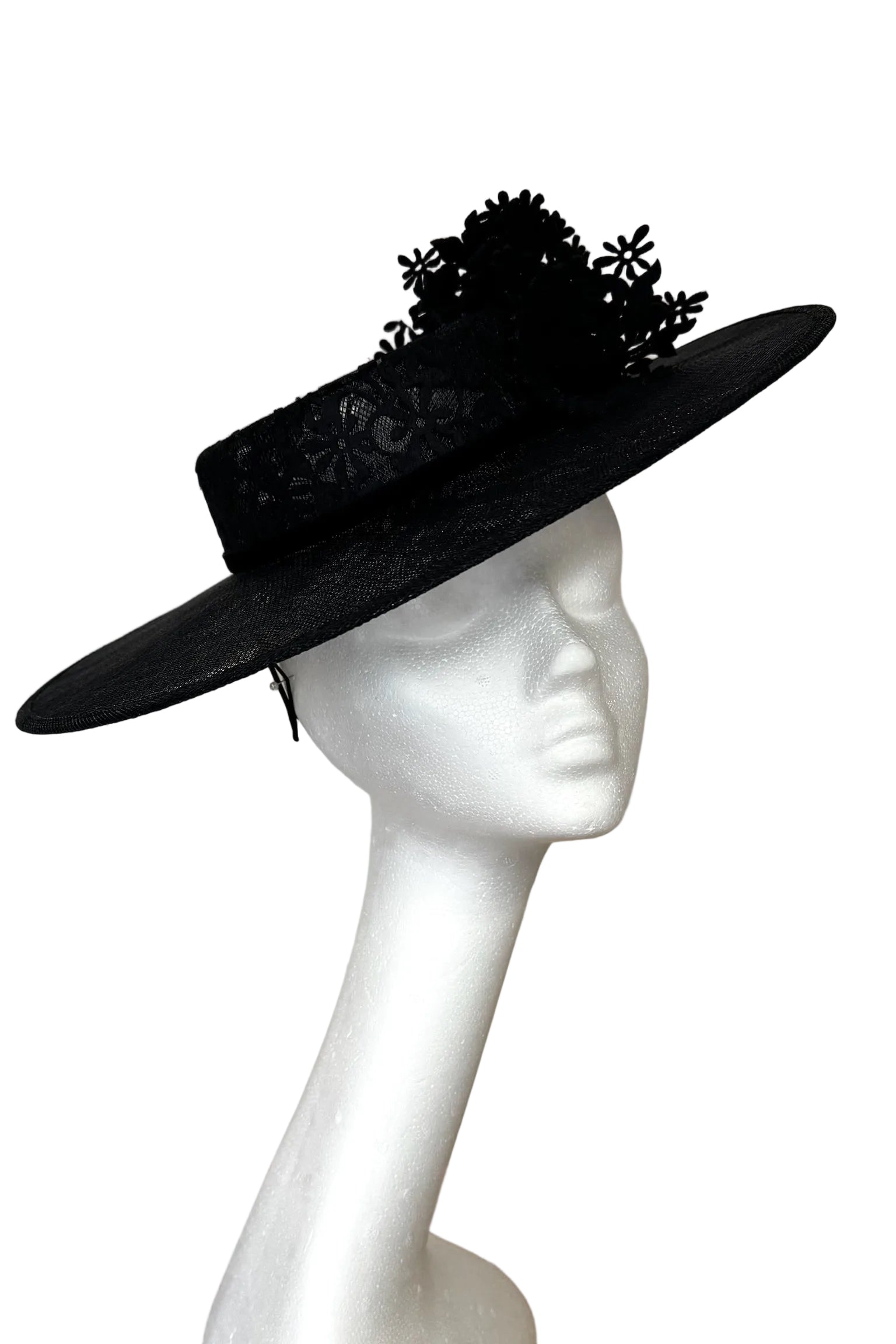 Black wide-brimmed hat with floral details on a mannequin head against a white background