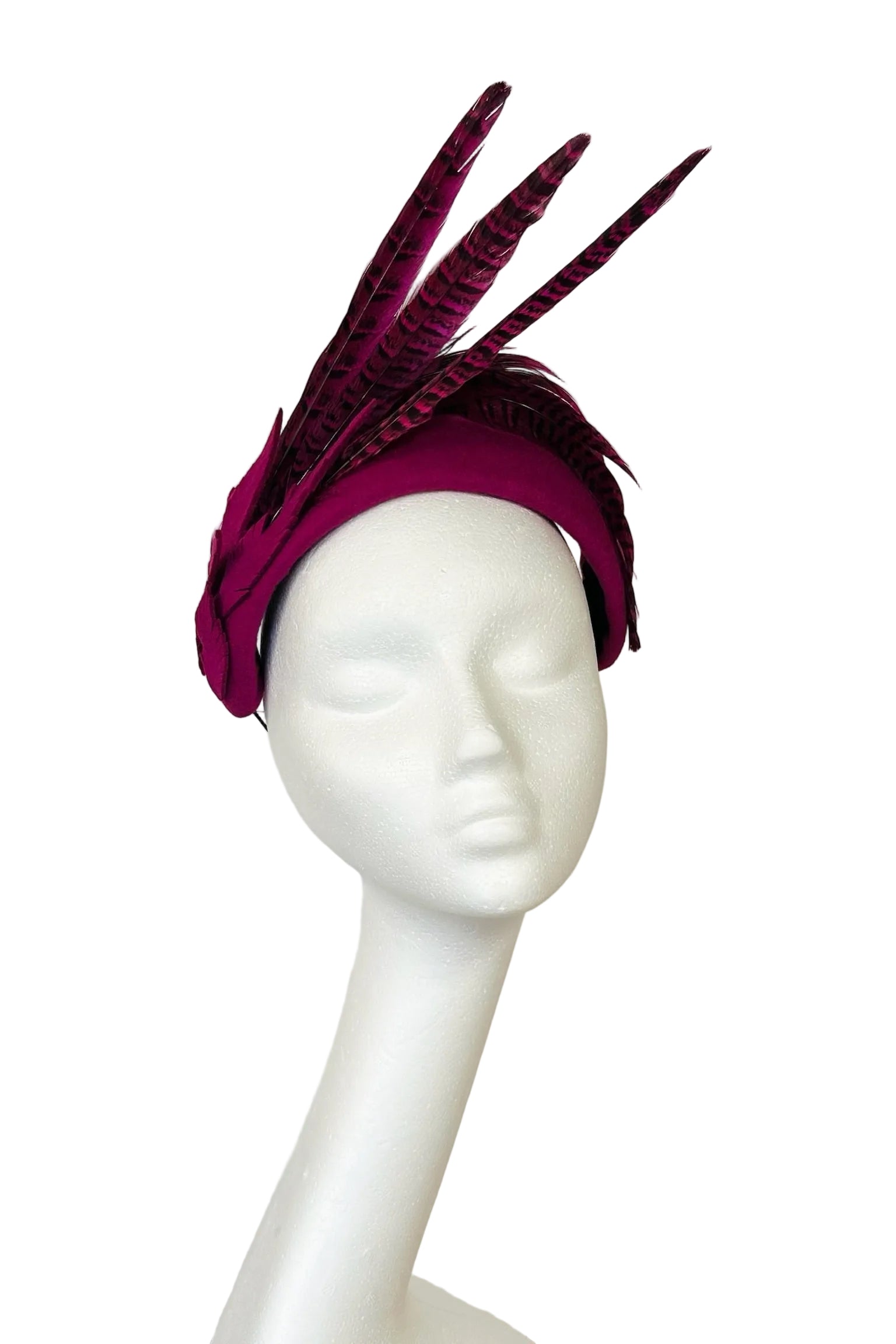 Pink headband with feather accents on a mannequin head against a white background