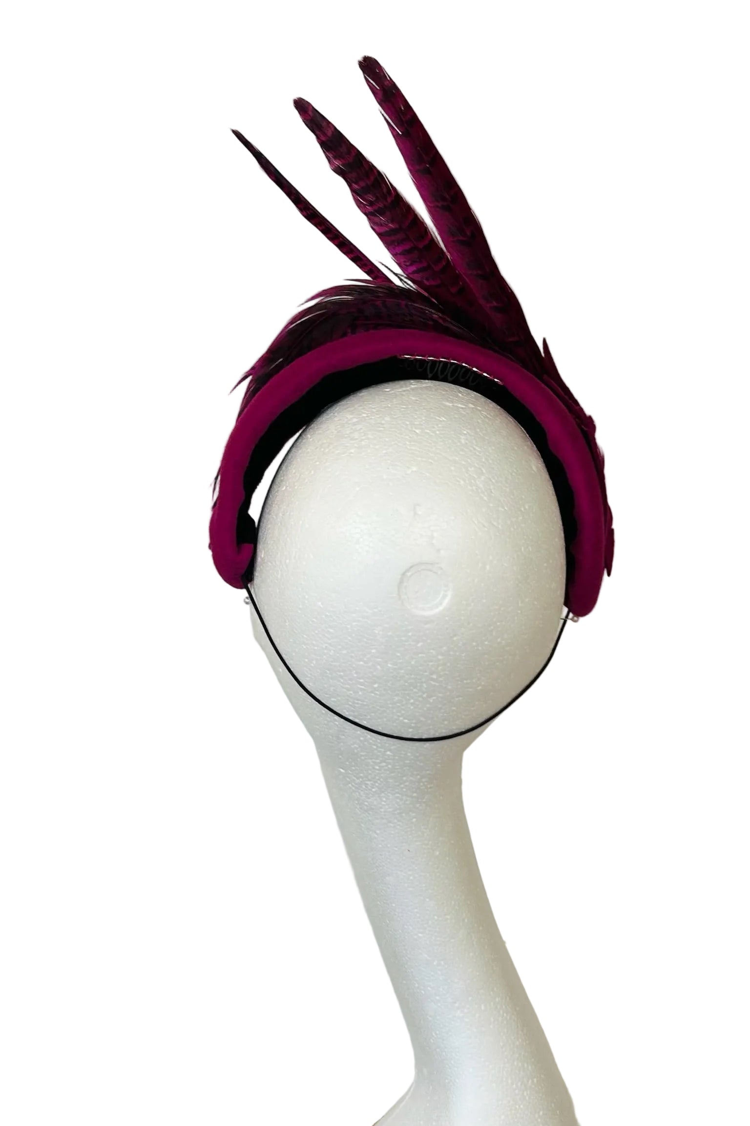 Pink feathered headpiece on a mannequin head against a white background