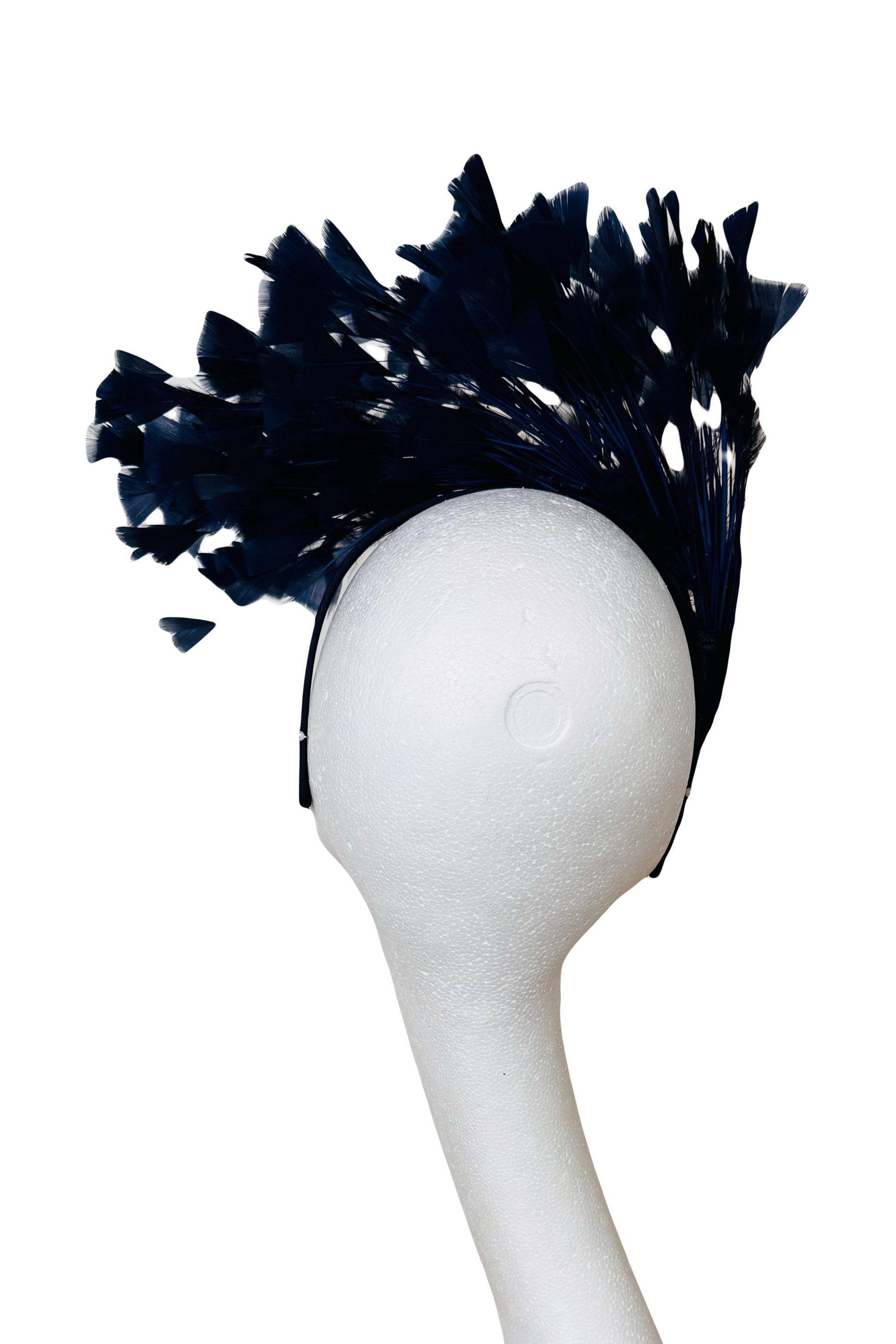 Navy feathered headpiece on a white mannequin head against a white background